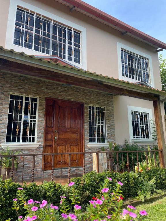 a house with a wooden door and some flowers at La Casa de Sonya in Concepción de Ataco