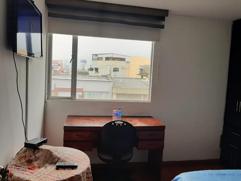 a room with a desk in front of a window at Hotel Roma Bogota , Corferias , Cerca Embajada Americana , Universidad Nacional , G 12 ,Movistar Arena Agora Habitaciones y Apartaestudios muy bien ubicado a 30 minutos del Aeropuerto in Bogotá