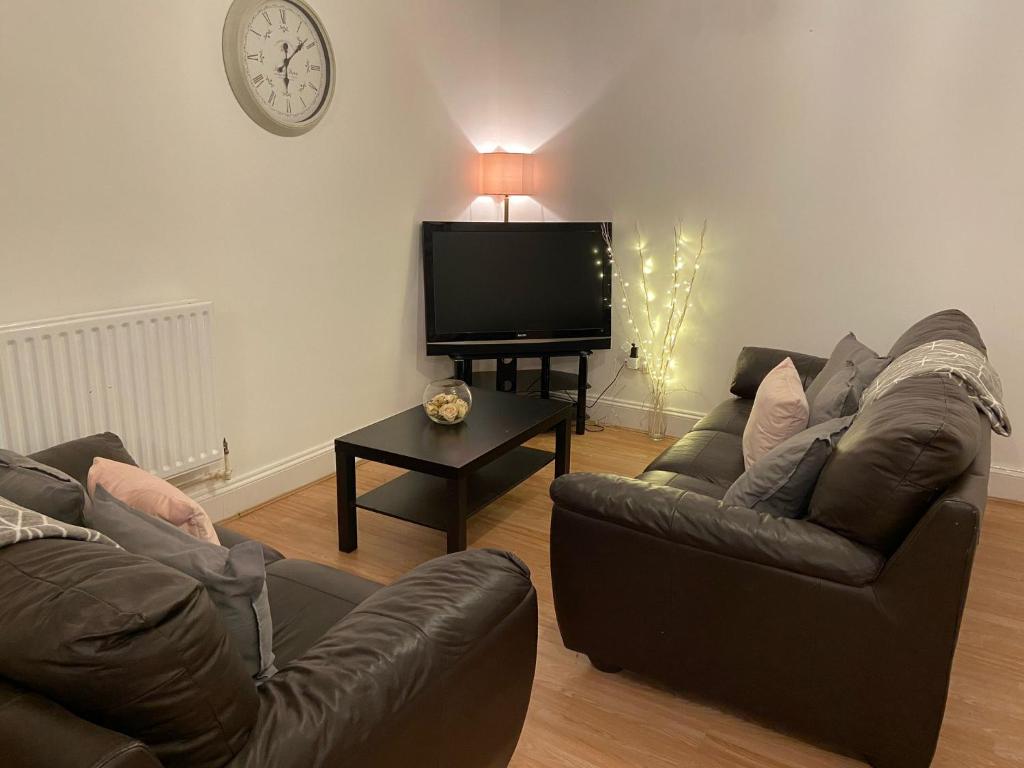 a living room with two couches and a flat screen tv at 2 Bed Deluxe Apartment, City Centre, Allocated Parking, Fast WiFi by Opulent Stays in Derby