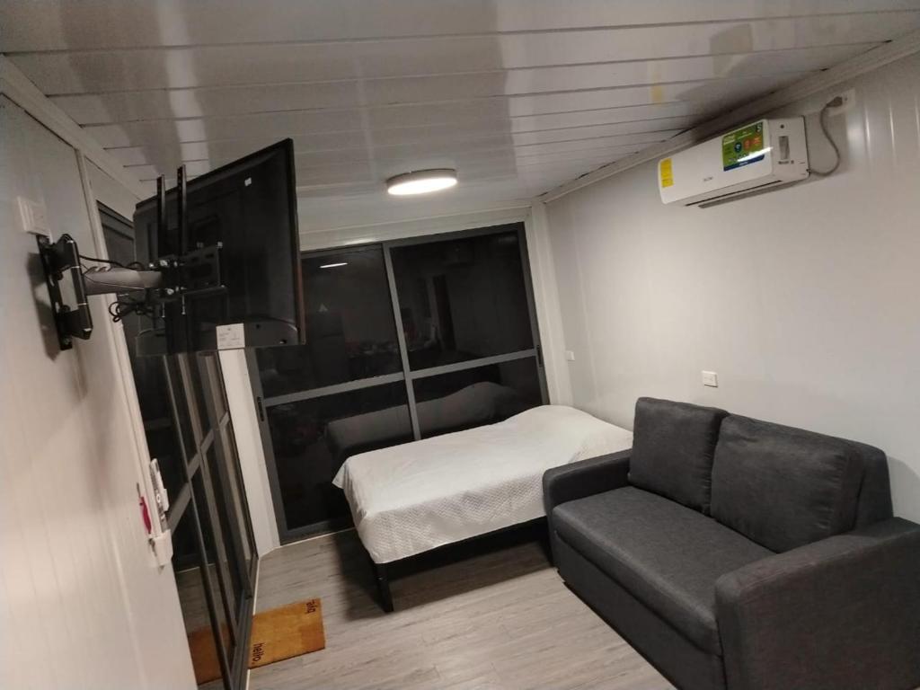 Habitación pequeña con sofá y cama en EcOsaLodge, en Puerto Jiménez