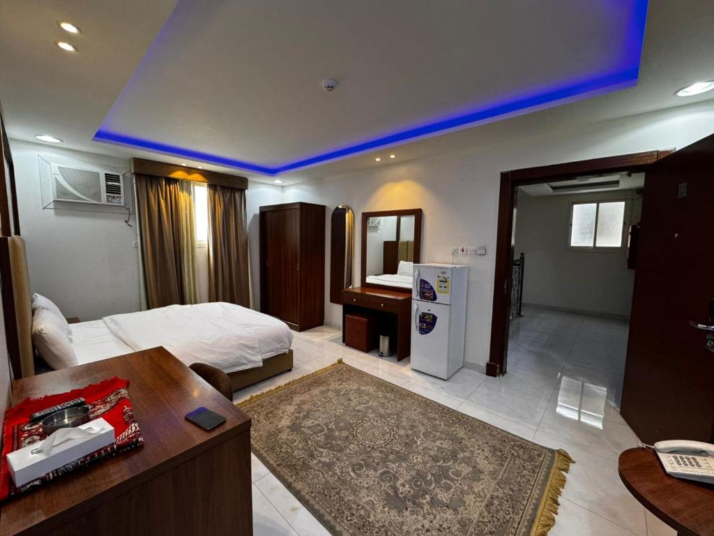 Una habitación de hotel con una cama y un escritorio y una habitación. en شقق ظل النخيل للشقق المخدومة, en Hotat bani tamim