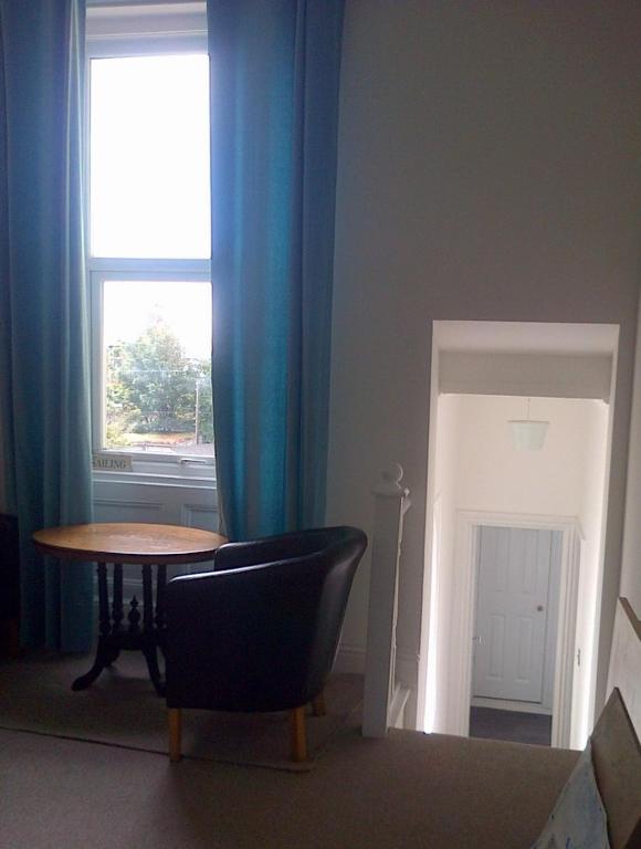 a room with a table and a chair and a window at Andorinho Sea View Apartment in Margate