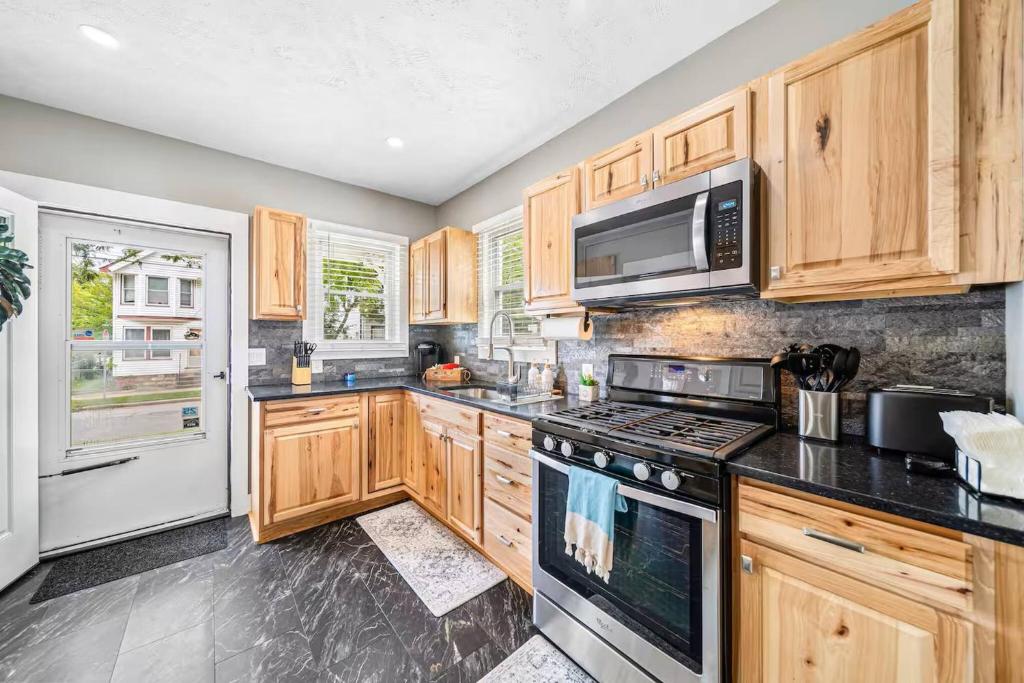a kitchen with wooden cabinets and a stove top oven at Updated Lakewood Retreat! in Birds Nest