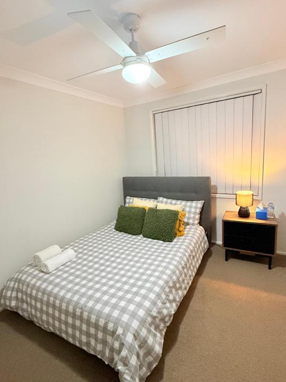 a bedroom with a bed with a ceiling fan at Jordan Springs - Home in Kingswood