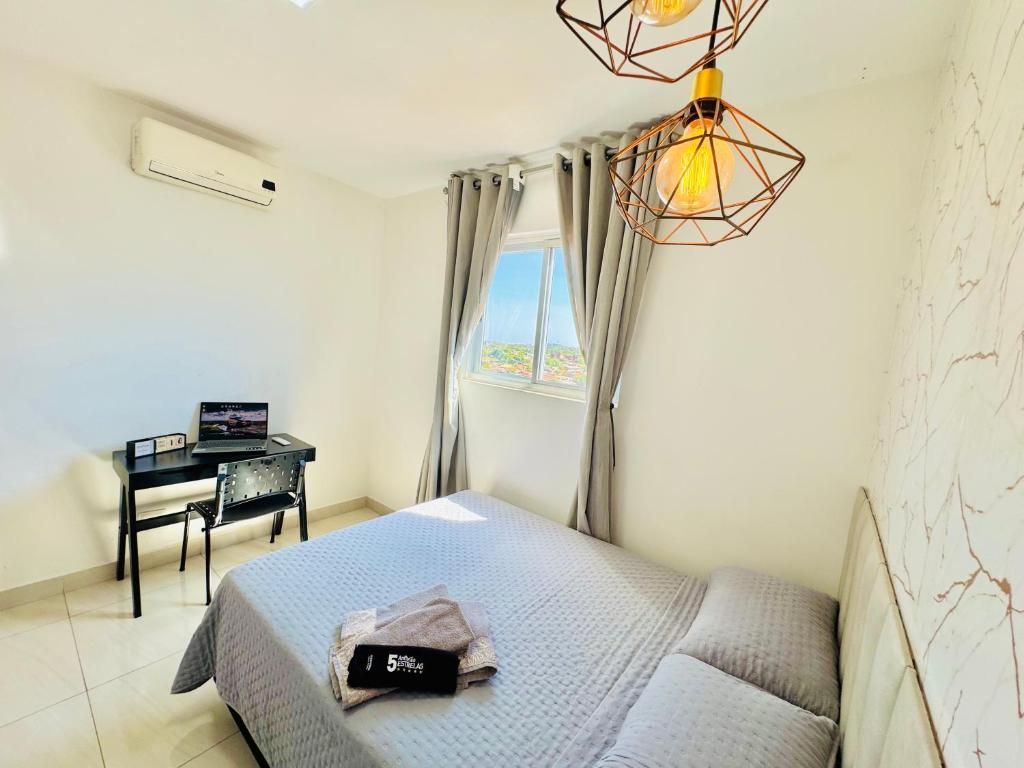 una camera da letto con un letto, una scrivania e una finestra di Apê ideal para Você, com Academia e Piscina a Cuiabá