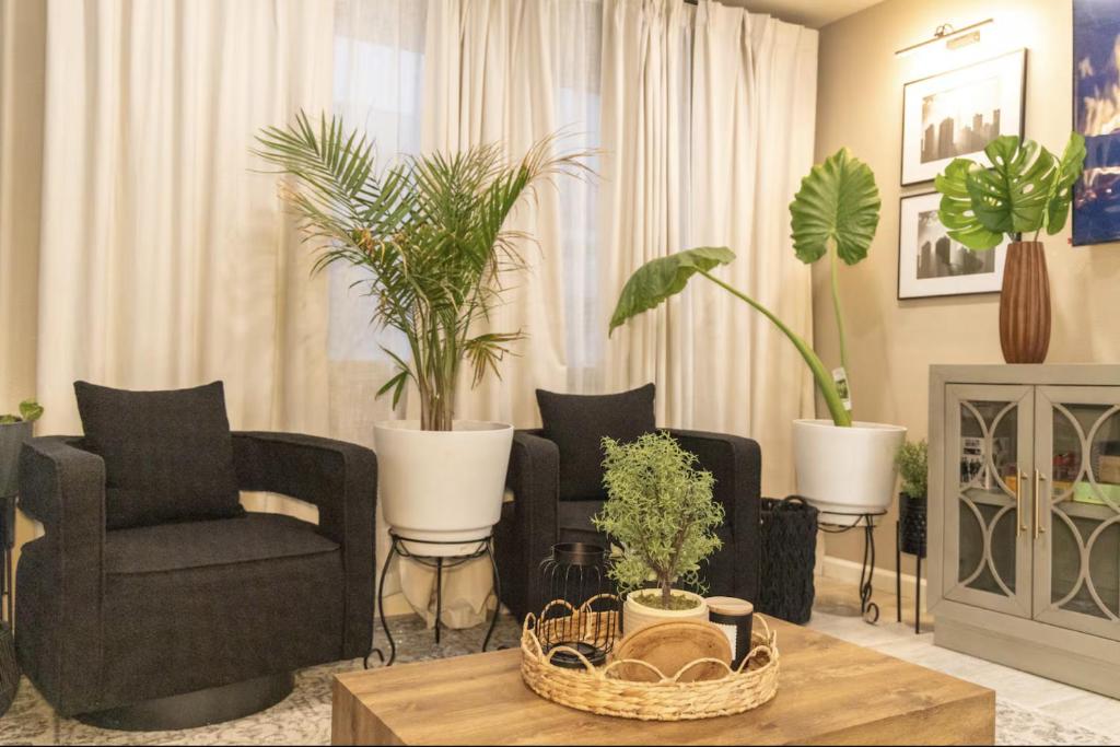 a living room with two chairs and potted plants at Sequoia Oasis near Downtown Exeter in Exeter