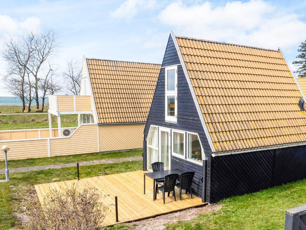 a black house with a deck and a table at Seaside Escape in Gedser - By Traum Ferienwohnungen in Gedser