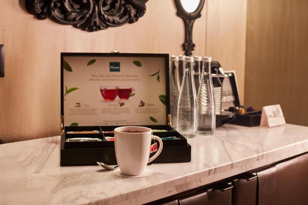 A marble counter with coffee, tea supplies, bottled water and an in-room hospitality card.