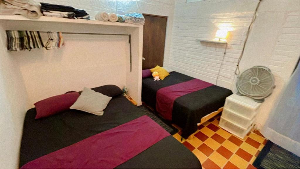 a room with two beds and a fan at Recamara Alan en Zona Romantica Departamento compartido con el host in Puerto Vallarta