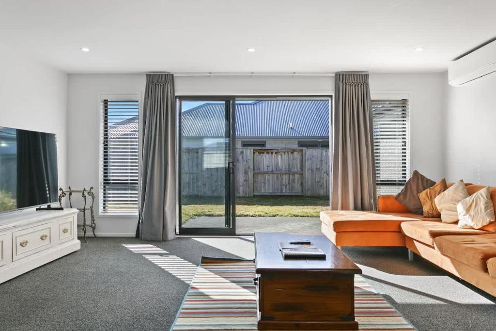 a living room with a couch and a tv at Huka Falls Getaway (Family escape) in Taupo