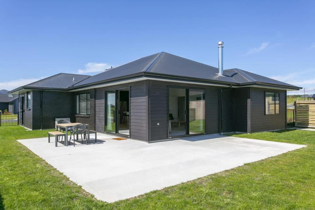 ein Gewächshaus mit einem Tisch und Stühlen in einem Hof in der Unterkunft Sophistication Meets Relaxation in Taupo