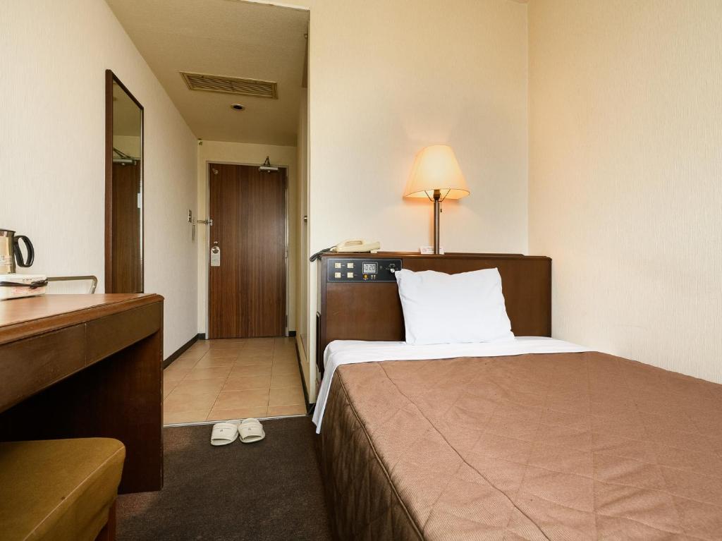 a hotel room with a bed and a bathroom at ホテル亀山ヒルズ in Kameyama