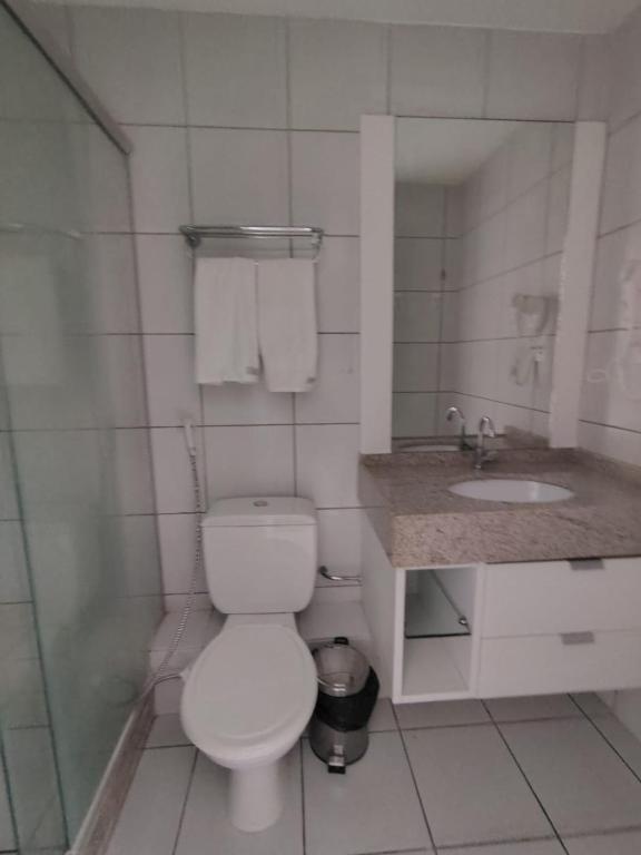 a white bathroom with a toilet and a sink at Resort Grand solare residence in Barreirinhas
