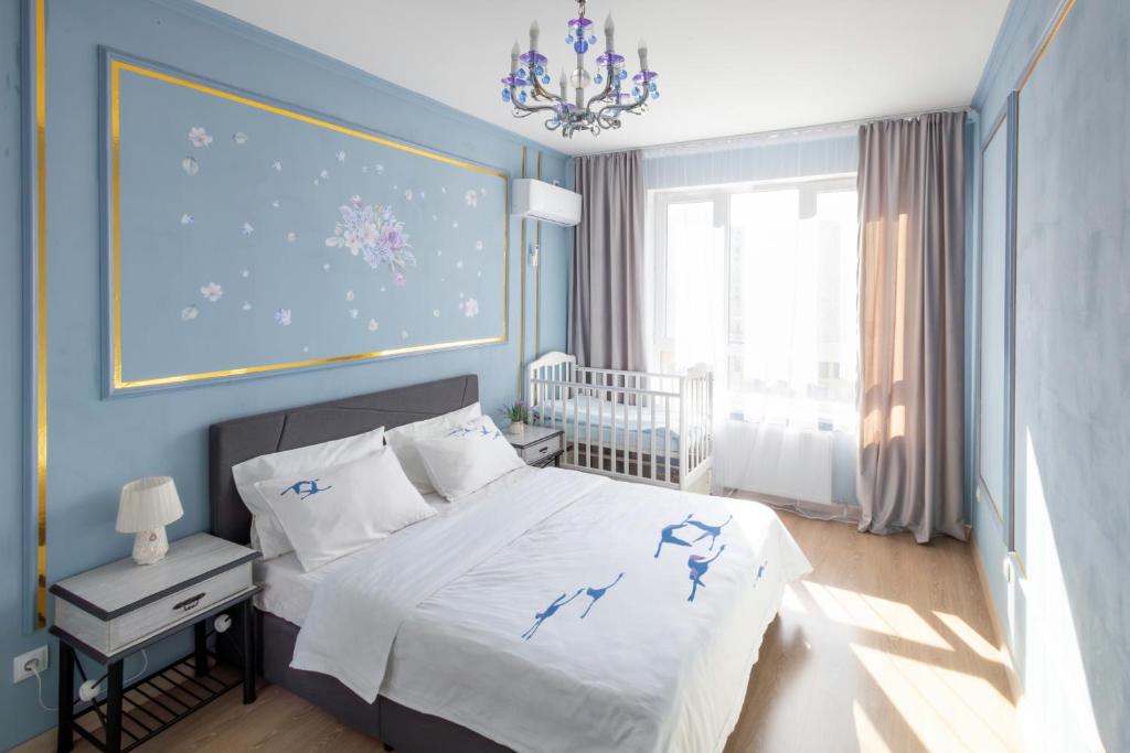 een slaapkamer met een bed en een blauwe muur bij Central Lifestyle in Astana