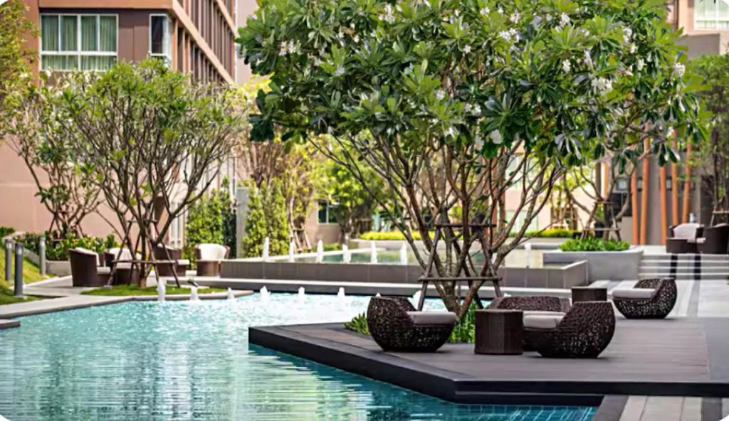 カトゥーにあるLuxury Condo Near Patong Beach & Shopping Mallの木々のある建物内のスイミングプール