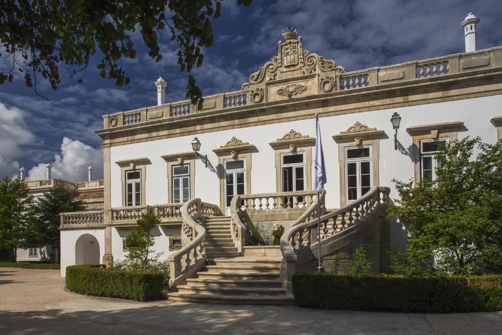 ein großes weißes Gebäude mit einer Treppe davor in der Unterkunft Hotel Quinta das Lagrimas - Small Luxury Hotels in Coimbra