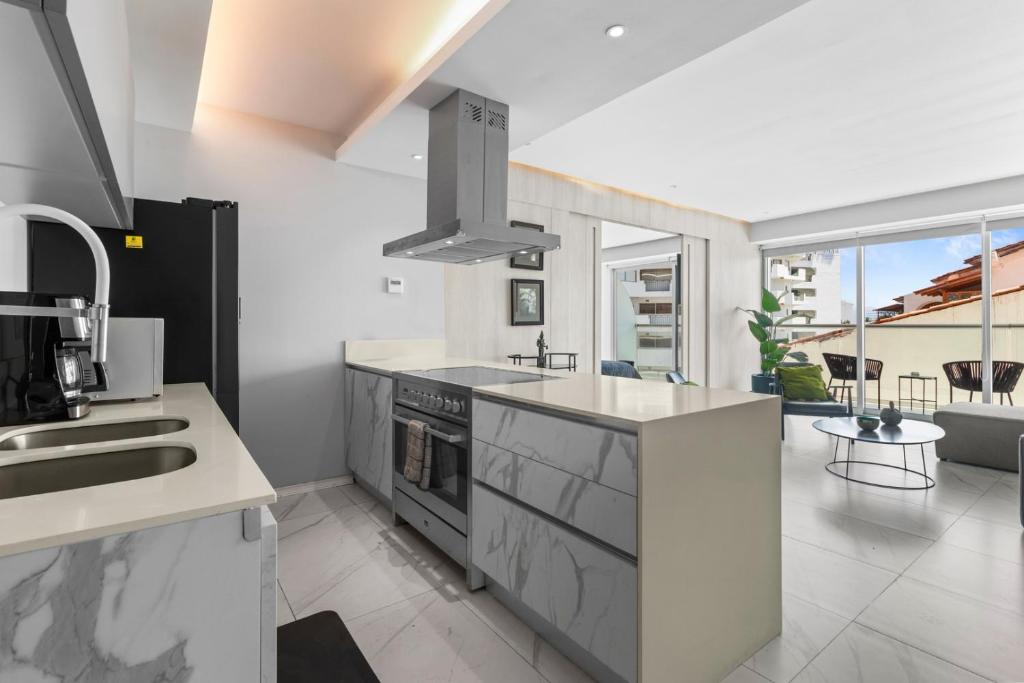a kitchen with a sink and a stove top oven at Marina Vallarta with View and Pool in Puerto Vallarta