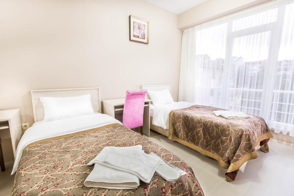 a bedroom with two beds and a window at Evren Konukevi Pansiyon in Bolu