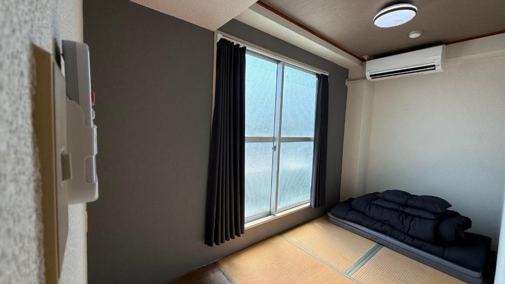 大阪市にあるNamba Ambers Hostel 6604の窓付きの客室で、ベッドが正面に備わります。