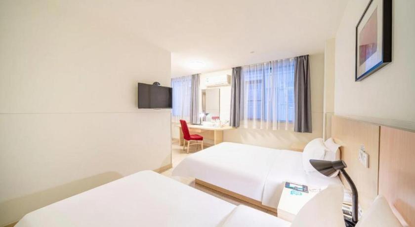 a hotel room with two beds and a desk at Jinjiang Inn Guangzhou Liwan Caihongqiao Metro Station in Guangzhou