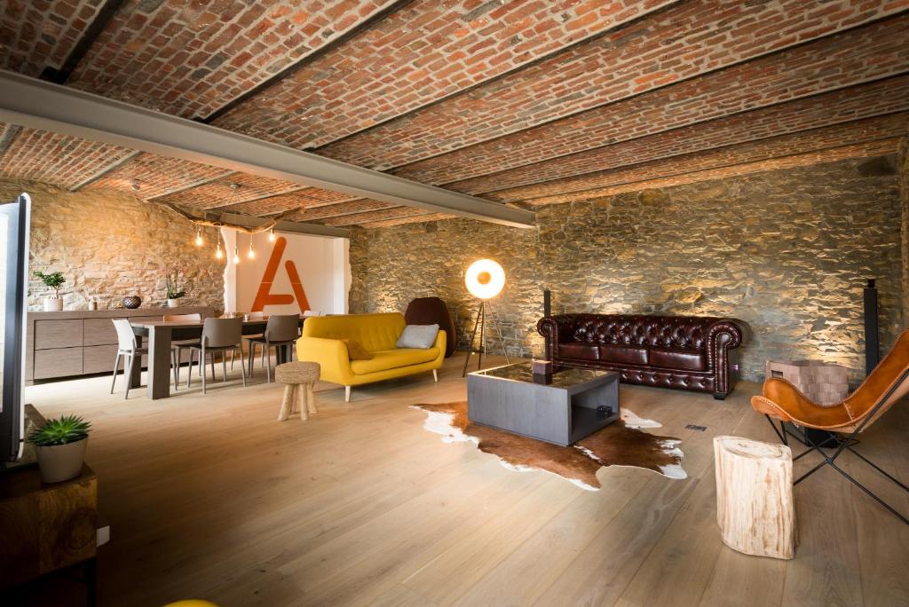 a living room with a couch and a brick wall at L'atelier in Hestreux