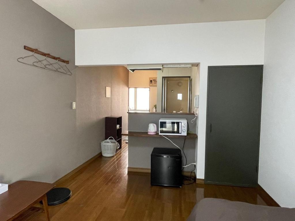 an empty room with a kitchen and a microwave at Chambord Kyomachi 102-202 - Vacation STAY 97549v in Kumamoto