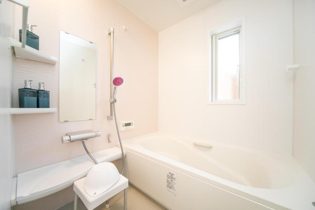 ein weißes Badezimmer mit Badewanne und Toilette in der Unterkunft Shizuki no Sato Tsuki Terrace 531 - Vacation STAY 98450v in Awaji