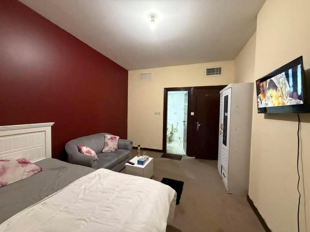 a bedroom with a bed and a couch and a flat screen tv at Riviera Retreat in Varanasi