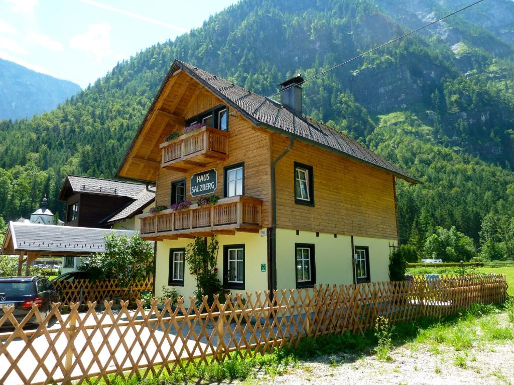 a wooden house with a fence in front of a mountain at Haus Salzberg in Hallstatt