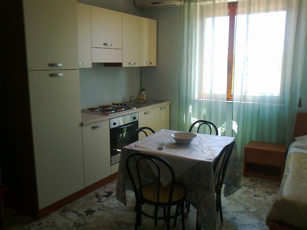 
a kitchen with a table and chairs and a refrigerator at Hotel L'Approdo in Brindisi

