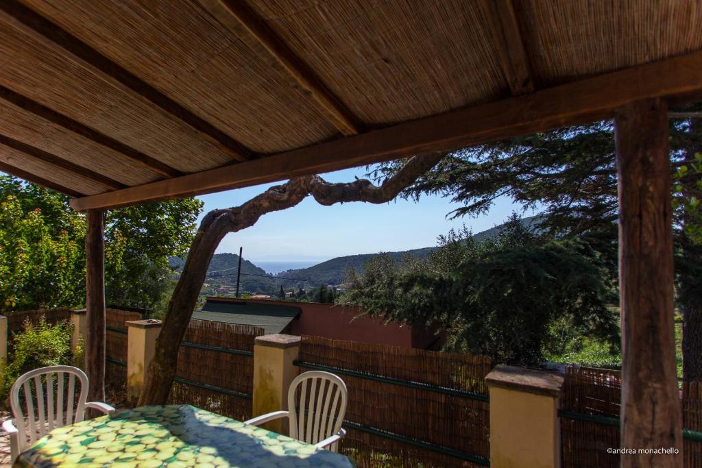 a patio with a table and chairs and a view at Agriturismo la Lecciola in Rio nellʼElba