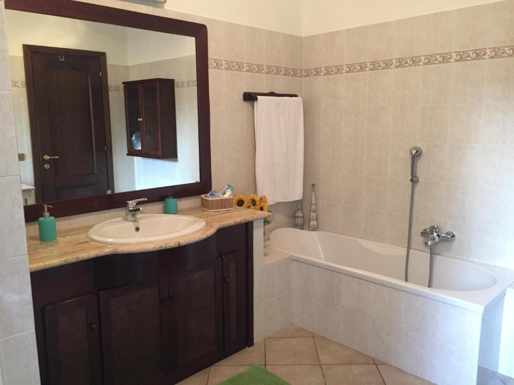 a bathroom with a sink and a tub and a mirror at Casale Del Borgo in Hermada