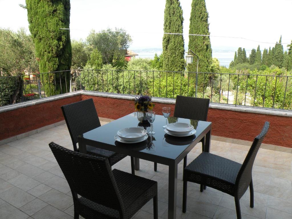 einen Tisch und Stühle auf einer Terrasse mit Aussicht in der Unterkunft Suite Deluxe a Villa Paradiso in Sirmione