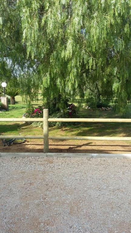 a wooden fence in a park with a tree at Casale Del Borgo in Hermada