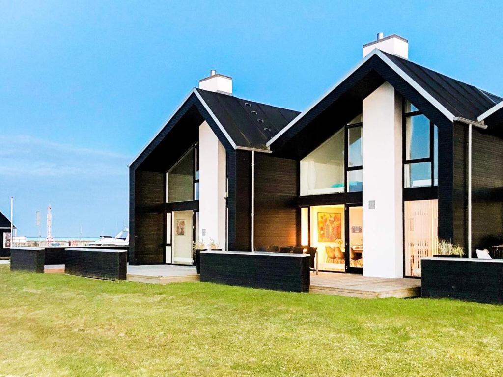 a black and white house on a green field at 8 person holiday home in Hadsund-By Traum in Øster Hurup
