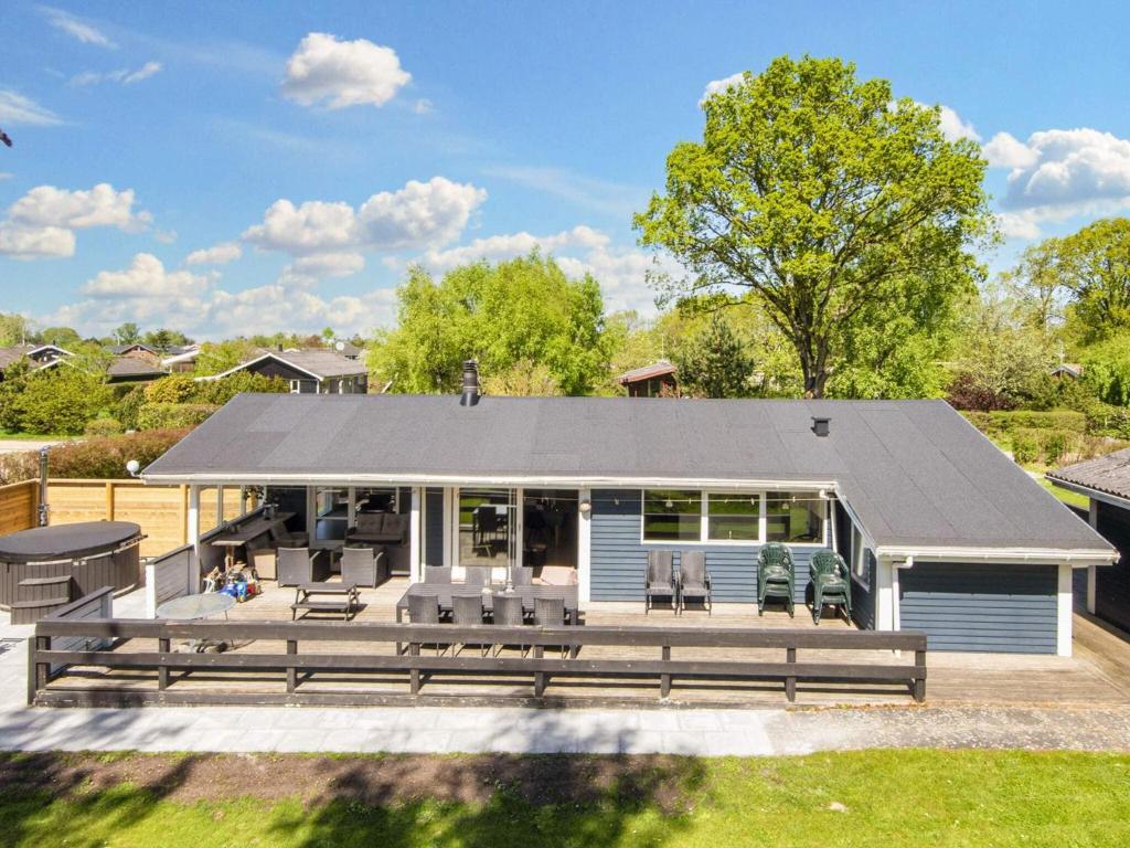 a house with a large deck with chairs at 10 person holiday home in Glesborg-By Traum in Glesborg