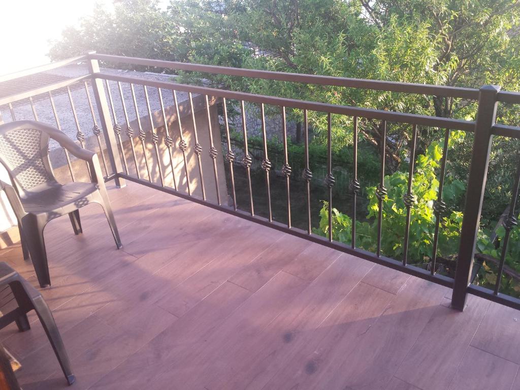 a chair sitting on a deck with a railing at Guest House Sombrero in Senj