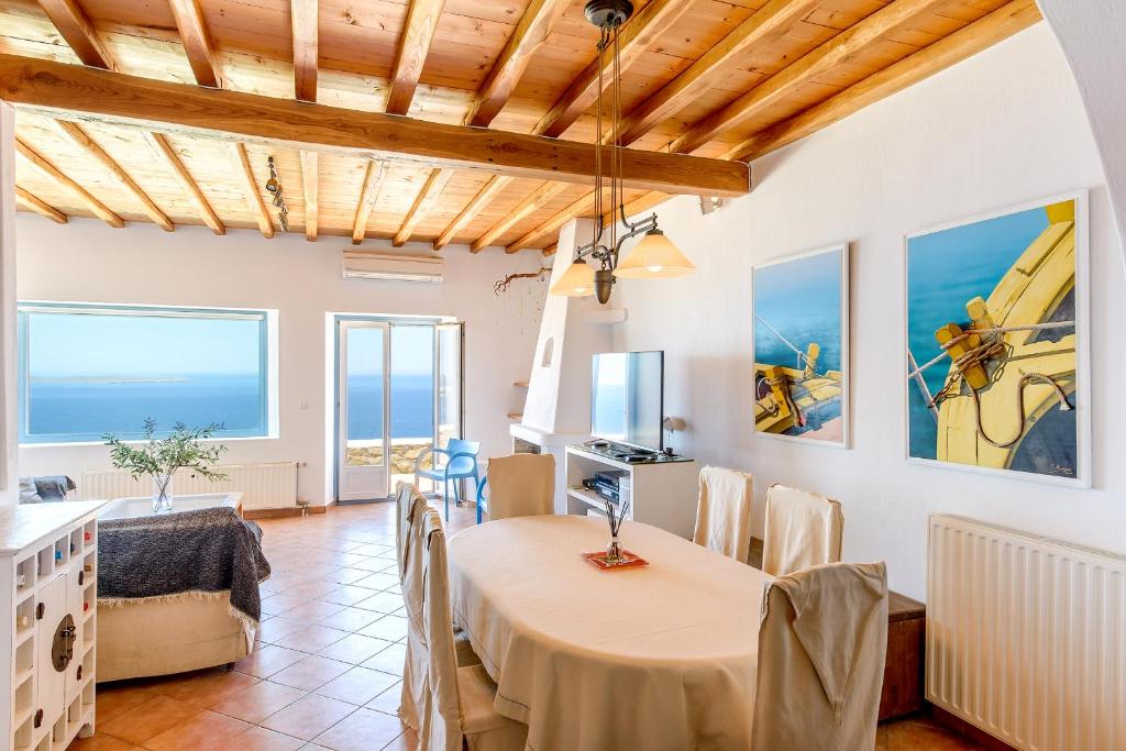 una sala de estar con mesa y sillas y el océano en Sunset Villa, en Houlakia