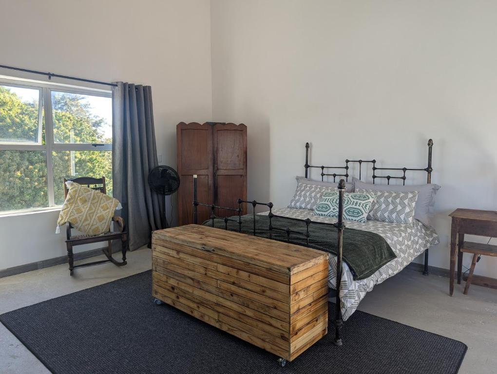 a bedroom with a bed with a wooden chestituresitures at Walmer Haven - Cosy Retreat in Gqeberha