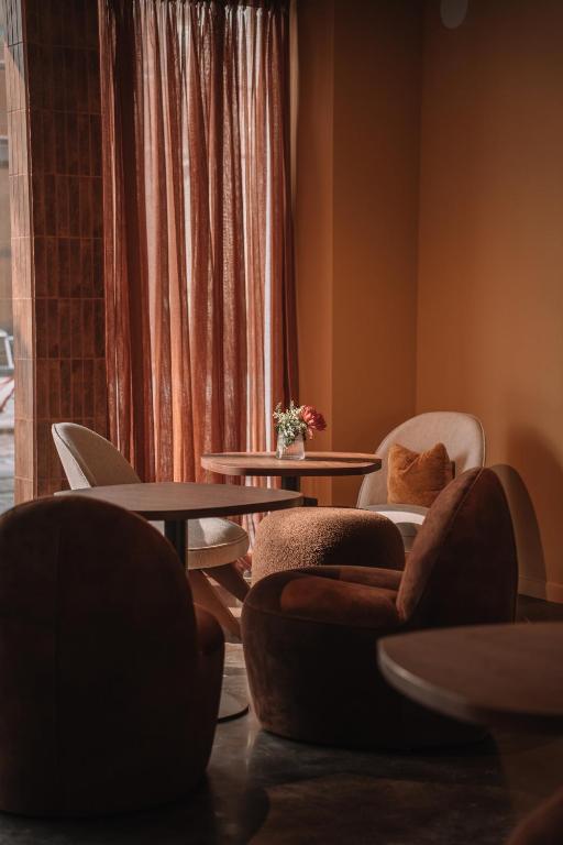 a living room with chairs and tables and a window at SKIPR Hotel - adults only in Antwerp
