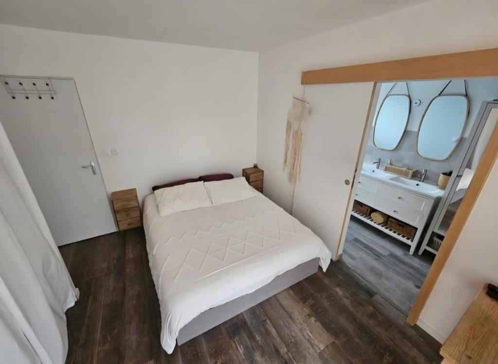 a bedroom with a white bed and a sink at Charmante maison de vacances in Saint-André-de-Cubzac
