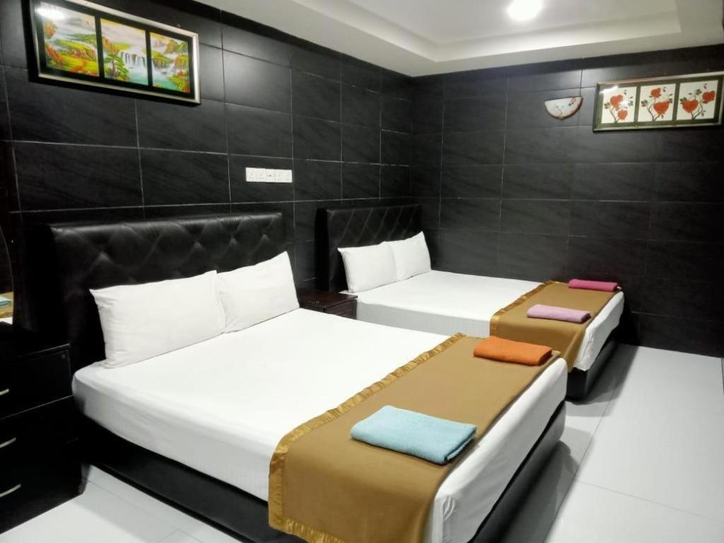 two beds in a small room with black walls at Kota Damansara Business Hotel in Kepong Cubitt Forest Village
