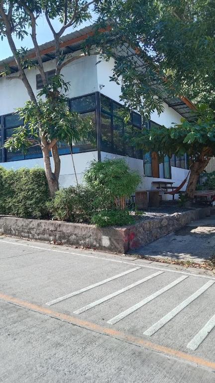 a building with a bench in front of a street at Papaya House Koh Tao in Ko Tao