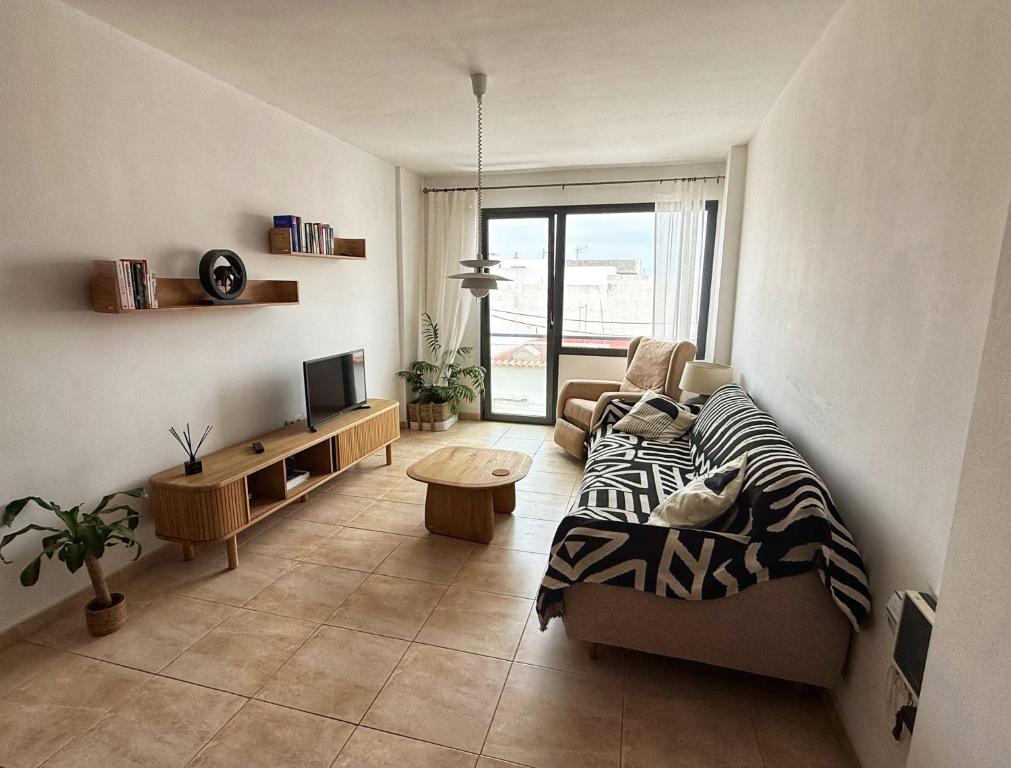un salon avec un canapé et une télévision dans l'établissement Casa Dana El Cotillo with private terrace, à El Cotillo