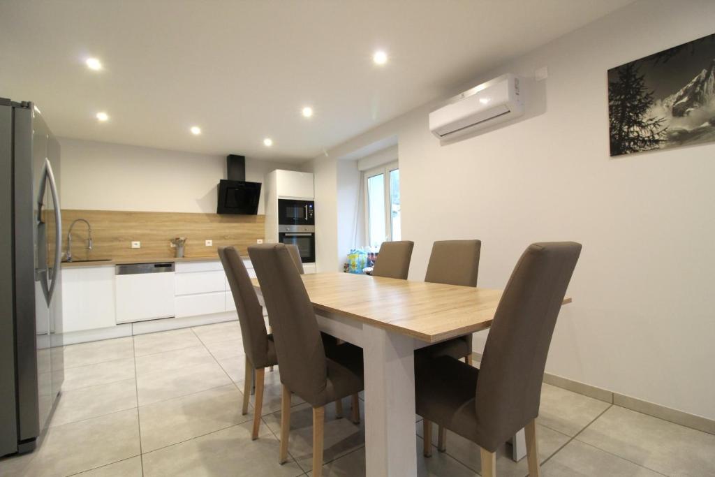a kitchen and dining room with a wooden table and chairs at Appartement à La Bresse, proche des lacs, pistes de ski et randonnées in La Bresse