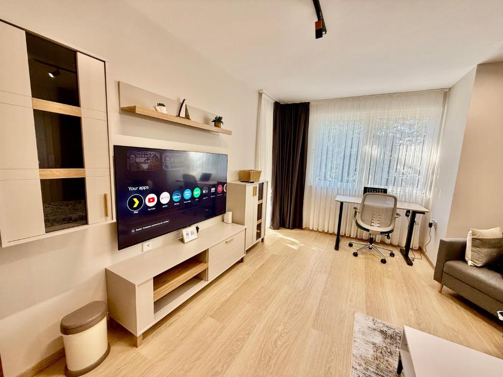 Una sala de estar con un televisor de pantalla plana grande. en Beach Please Apartment, en Burgas