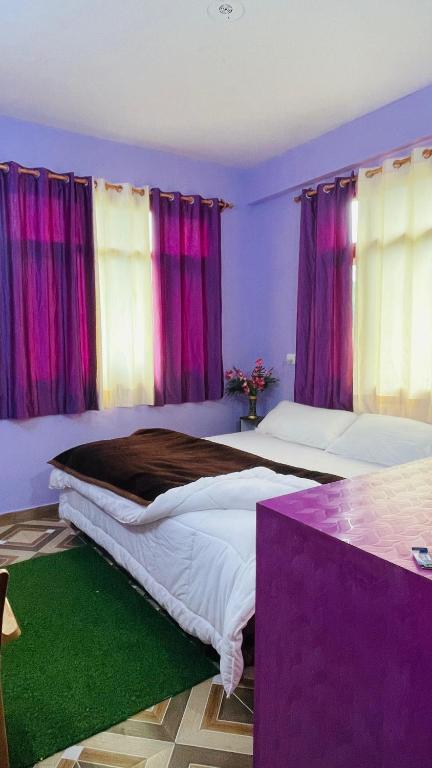 a bedroom with two beds and purple curtains at Mayank homestay shimla in Shimla