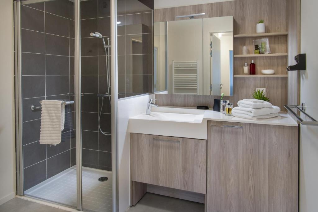 a bathroom with a sink and a shower at DOMITYS - Les Canotiers in Argenteuil