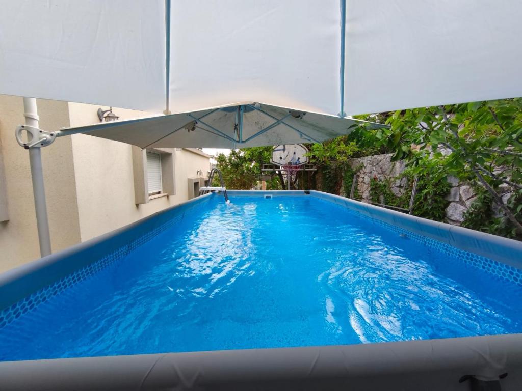 a large blue swimming pool with an umbrella over it at Noam Hamargalit in Kefar Weradim