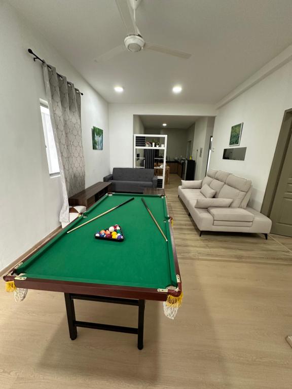 a living room with a pool table in the middle at Ayaan Snookers Home 3 at Quintet Apartment with Private Parking in Tanah Rata